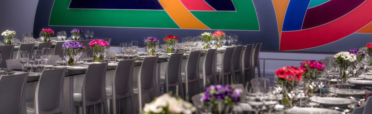 design bankettstuehle in weiss an langen tischen mit eventdekoration