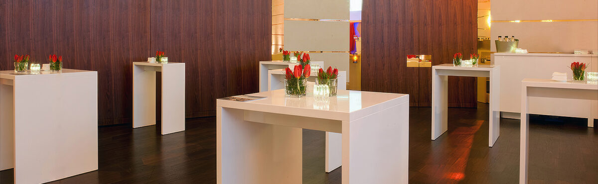 grosser apéro stehtisch in einem eventsaal mit blumendekoration