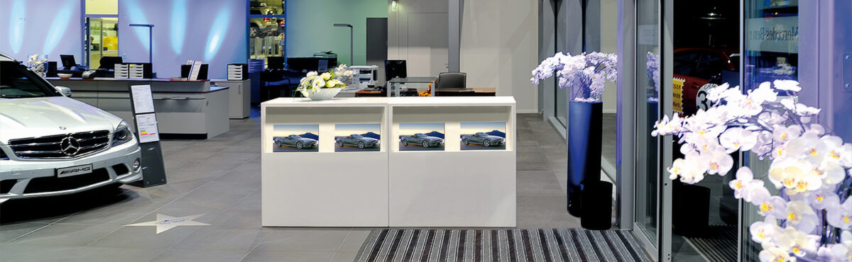exklusiver receptions desk mit katalogfach in einem autoverkaufsbereich