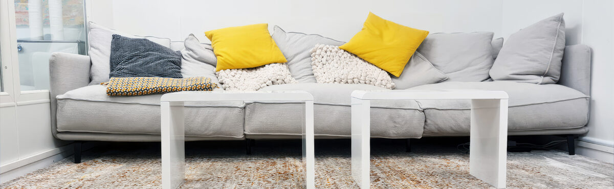 grosses sofa mit weissen loungetischen in einem besprechungsraum