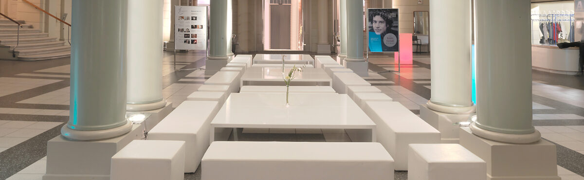 weisse event lounge mit grossen tischen in einer saeulenhalle