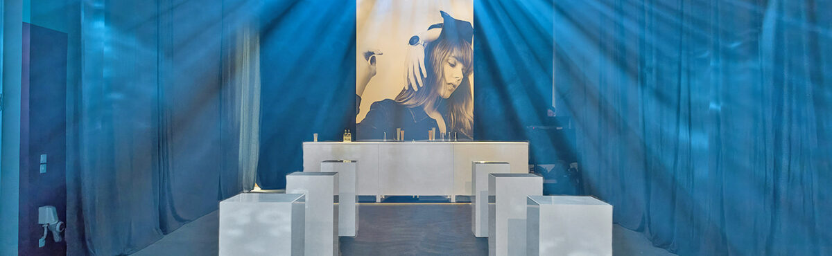exklusiver event barbereich mit weissen theken und saeulen stehtischen blau beleuchtet