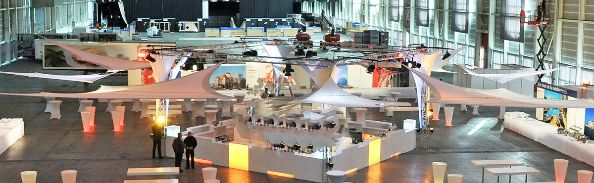 eventhalle mit grosser bar und led beleuchteten theken