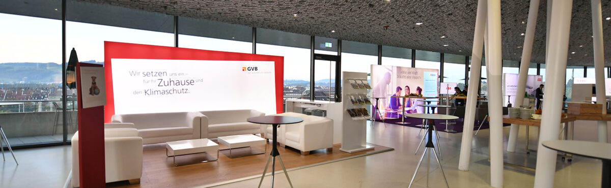 heller veranstaltungsraum mit weissen sofas und sesseln sowie eleganten beistelltischen