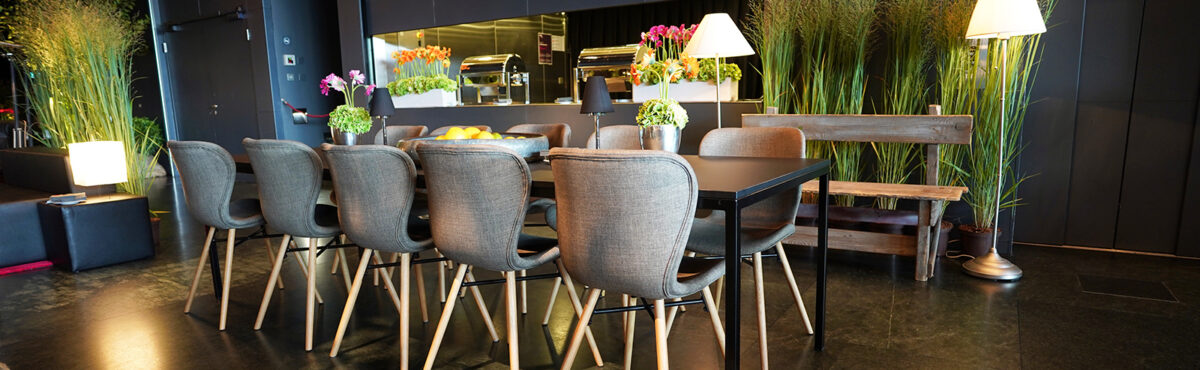 elegante stoff stuehle mit schwarzem banketttisch und stehleuchten an einem event