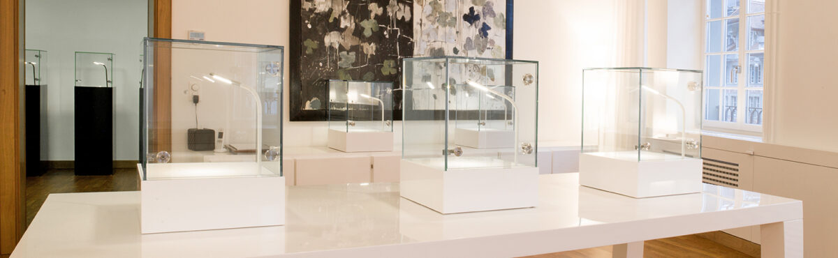 tischvitrinen in weiss mit beleuchtung in einem ausstellungsraum