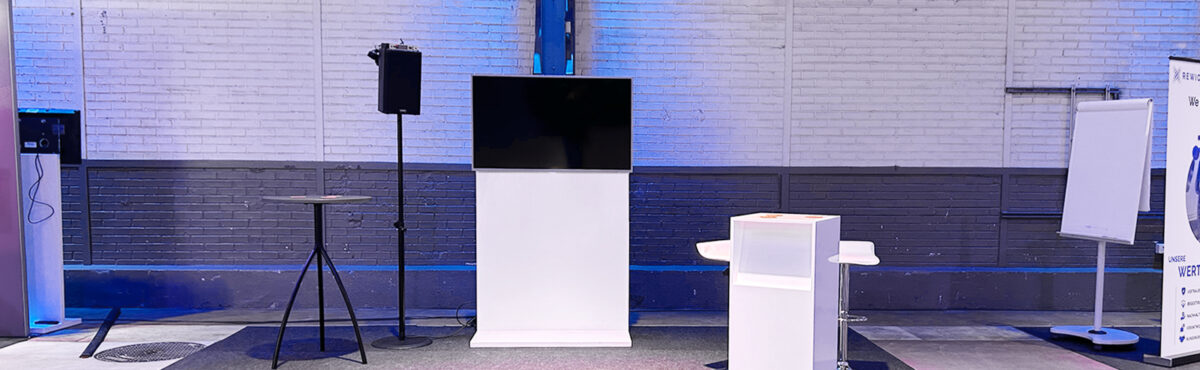 tv screen mit bodensteller und flipchart an einem messe stand